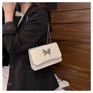 Detail of white glossy mini shoulder bag with silver liquid metal butterfly buckle