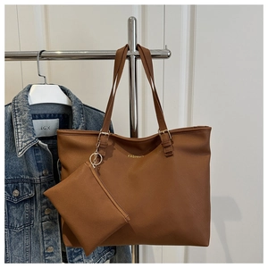 Detail of a brown leather tote bag with a small coin purse hanging on a metal hanger