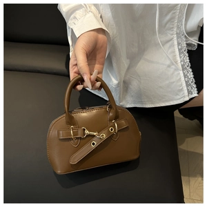 Dettaglio borsa a mano marrone vintage con fibbia dorata elegante e manico in pelle fine