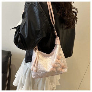 Model trägt eine rosa Spitzen-Achseltasche mit 3D-Schmetterlingen und Perlendetails