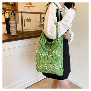 Détail d'un sac cabas en crochet vert avec perles blanches et maille ajourée élégante