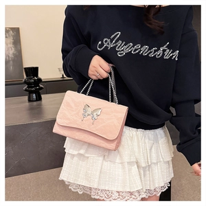 Detailed view of pink pleated shoulder bag with silver butterfly accent and chain strap