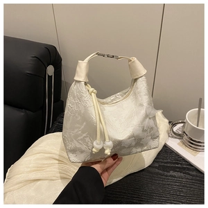 Détail du sac à main en dentelle blanche avec broderie florale et papillons en relief