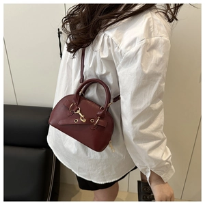 Dettaglio di una borsa a mano vintage rosso scuro a forma di conchiglia con finiture dorate