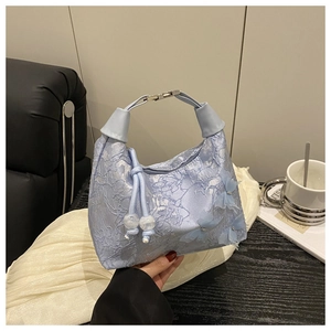 Détail du sac à main bleu clair avec papillons 3D et broderie texturée en dentelle