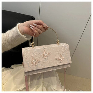 Close-up of 3D butterfly embroidery and floral lace texture on pink crossbody bag