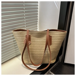 Détail du sac cabas en paille tressée avec motif en V et anses en cuir marron