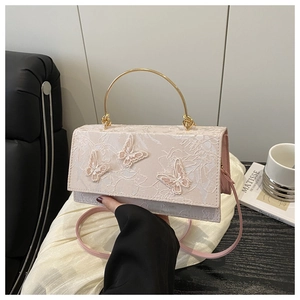 Close-up of pink lace handbag featuring 3D butterfly embroidery and gold metal handle