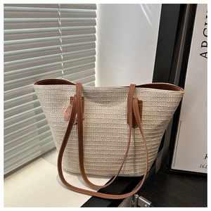 Détail du sac cabas tressé ivoire avec bandoulière en cuir et charm papillon rose