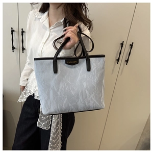 Détail du grand sac cabas gris avec texture marbre et étiquette du logo FASHION