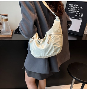 Detailed view of light green nylon hobo bag with unique yellow rope zipper pull