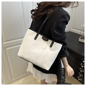 Detail of the high-capacity tote bag showing marble texture and fashion label
