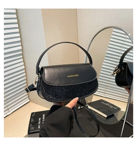 Detail of black crossbody bag with glitter finish and gold Fashion text inscription