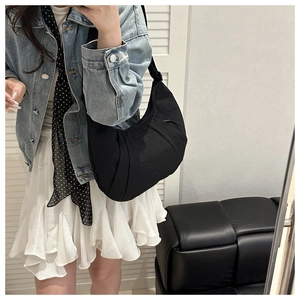 Mirror selfie showing the large black pleated crescent shoulder bag for daily outfit
