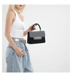 Detail of vintage patchwork crossbody bag featuring grey texture and golden metal lock