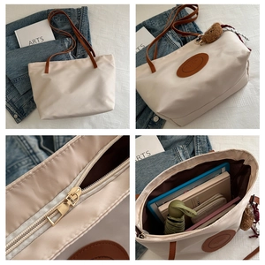 Detail view of large cream tote bag with brown straps and spacious zipper compartment