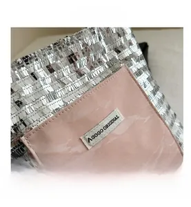 Close-up of woven silver sequins and pink marble texture patch with brand label