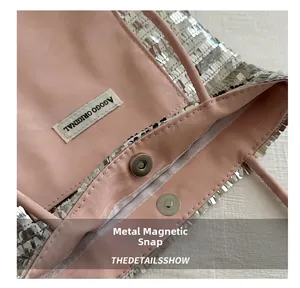 Detail of silver sequin tote bag with pink lining and magnetic metal buckle closure