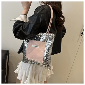 Detail of silver sequin tote bag with a pink front pocket and brand woven label