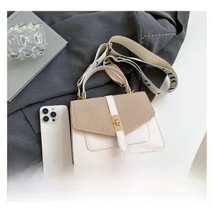 Détail du sac crème avec rabat à texture tissée et large bandoulière lettrée CHCI