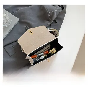 Vue de dessus d'un sac à rabat beige montrant la capacité pour maquillage et carnet