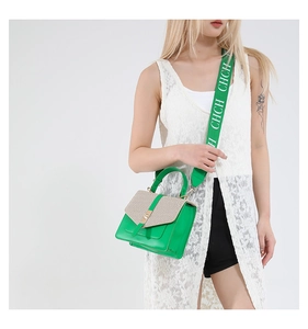 Détail d'un sac bandoulière vert et beige avec rabat tissé et large bandoulière en toile