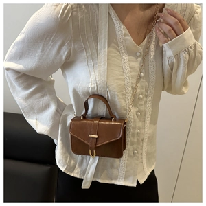 Brown vintage mini crossbody bag with metal chain strap and sleek leather texture