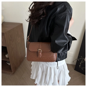 Brown woven texture PU shoulder bag with golden metal buckle shown on a model