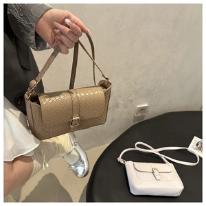 Close-up of woven pattern flap bags in brown and white with metallic buckle detail