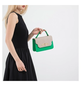 Dettaglio borsa color block con pelle verde, patta beige intrecciata e fibbia dorata