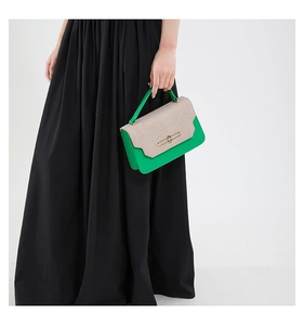 Dettaglio della borsa bicolore con trama intrecciata beige e inserti in pelle verde