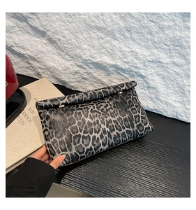 Detail view of leopard print clutch with gold ring hardware and foldable design