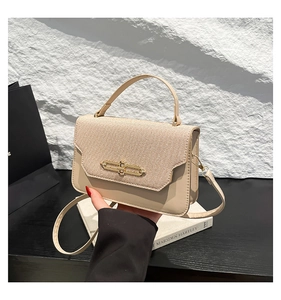 Dettaglio del tessuto beige testurizzato e borsa in pelle PU con fibbia in metallo