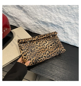 Detail of trendy leopard print clutch bag featuring a fold-over design and silver rivets
