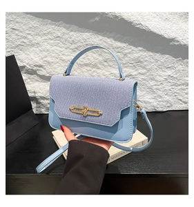 Dettaglio della borsa a mano in pelle PU azzurra e denim patchwork con chiusura dorata