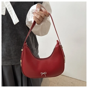 Detail of red crescent hobo bag with silver bow hardware and zipper closure