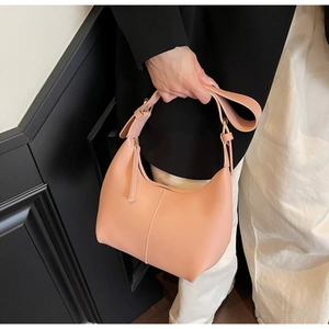 Detail of pink half-moon hobo bag with vertical stitching and golden zipper hardware