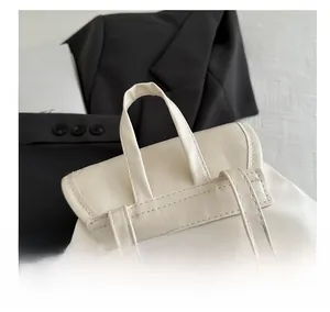 Close-up of white PU leather backpack handle with reinforced double-stitch craftsmanship