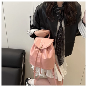 Close-up of pink PU leather backpack with metallic buckle and drawstring on a model