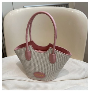 Detail of cream and pink woven bucket bag with leather top handles and Fashion label