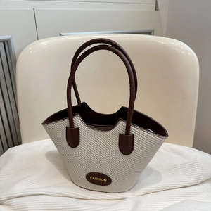 Chic beige woven tote bag with dark brown leather handles and Fashion logo detail