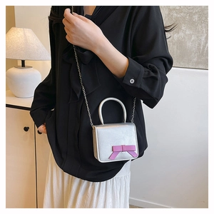Silver mini crossbody bag for girls with a purple bow and metal chain strap