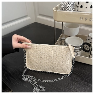 Détail d'une pochette enveloppe tissée blanc cassé avec perles argentées et chaîne métal