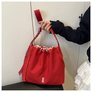 Detail of red canvas tote with drawstring checkered lining and Fashion label