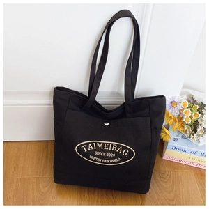 Close-up of black canvas tote bag showing magnetic silver button and interior detail