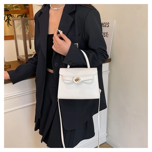 Detail of white leather Kelly bag showing the golden oval swivel lock and handle