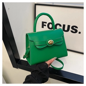 Close-up of vibrant green faux leather handbag featuring a golden oval twist lock