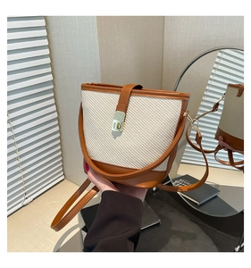 Détail du sac seau minimaliste montrant la texture tissée, les garnitures et le fermoir