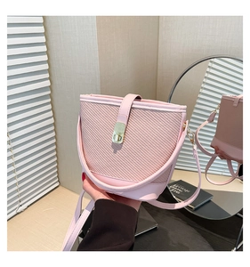 Détail du sac seau rose avec texture tissée en sergé et fermoir rotatif doré