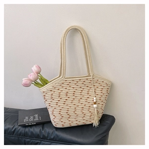 Dettaglio della borsa tote in cotone intrecciato con pois marroni e nappina bianca